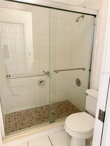 a white toilet sitting next to a shower
