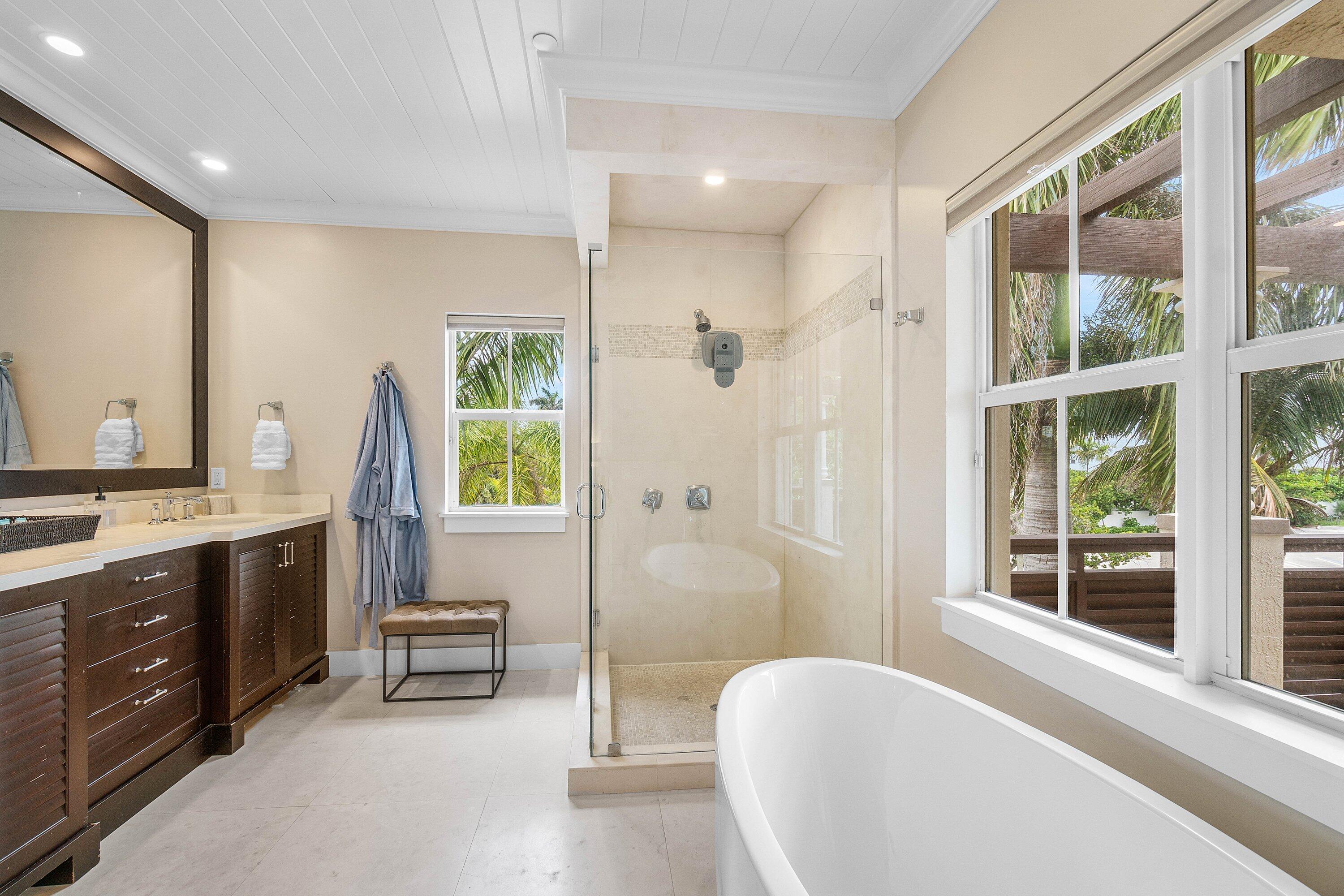1108 Coconut Row Delray Beach, FL 33483 - Photo 17 of 31 a spacious bathroom with a double vanity sink a large mirror and a bathtub