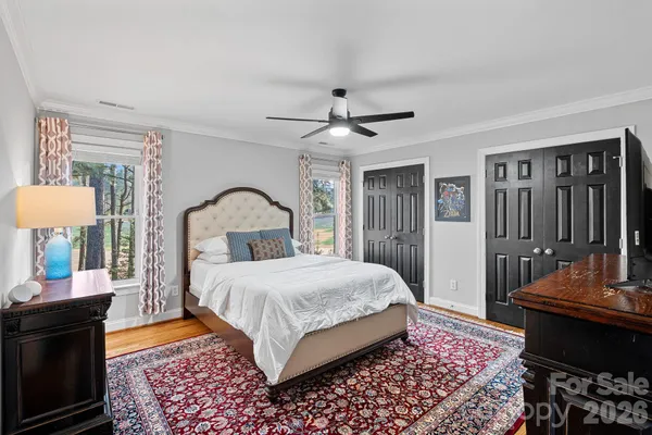 a bedroom with a bed and wooden floor