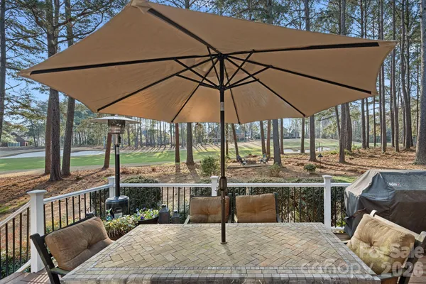 a patio with a table and chairs under an umbrella