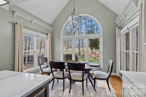 a dining room with furniture a chandelier and wooden floor