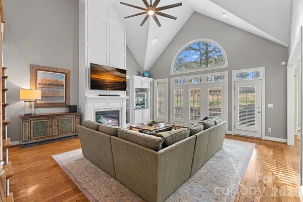 a living room with furniture a fireplace and a flat screen tv