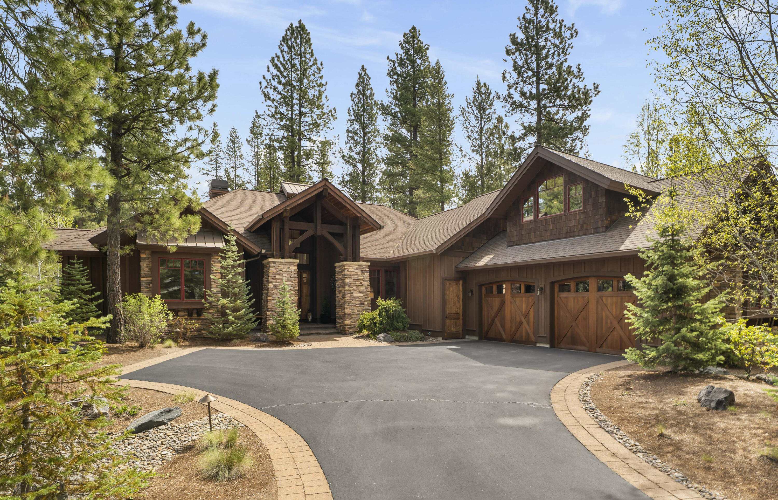 56155 Sable Rock Loop, Unit 277 Bend, OR 97707 - Photo 1 of 63 A stunning custom home built by Pineriver Homes - surrounded by towering pines, featuring rich timber accents, stacked stone columns, and an inviting grand entry.