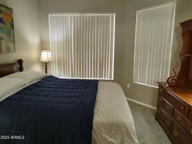a bedroom with a bed and a flat tv screen on the dresser