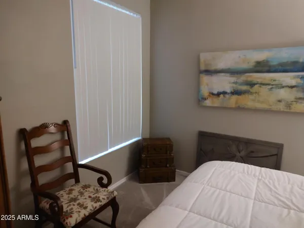 a bedroom with a bed and chair