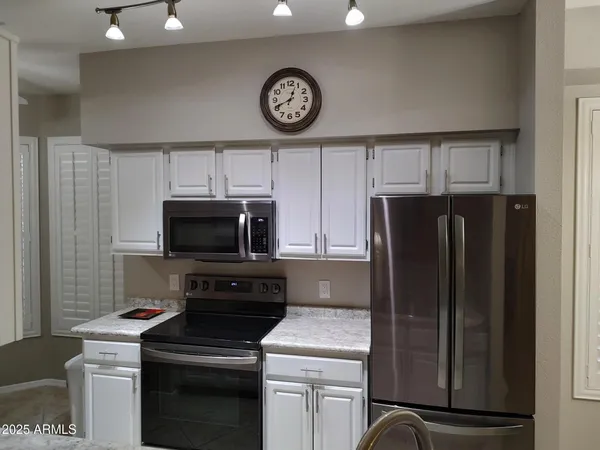 a kitchen with a refrigerator and a stove top oven