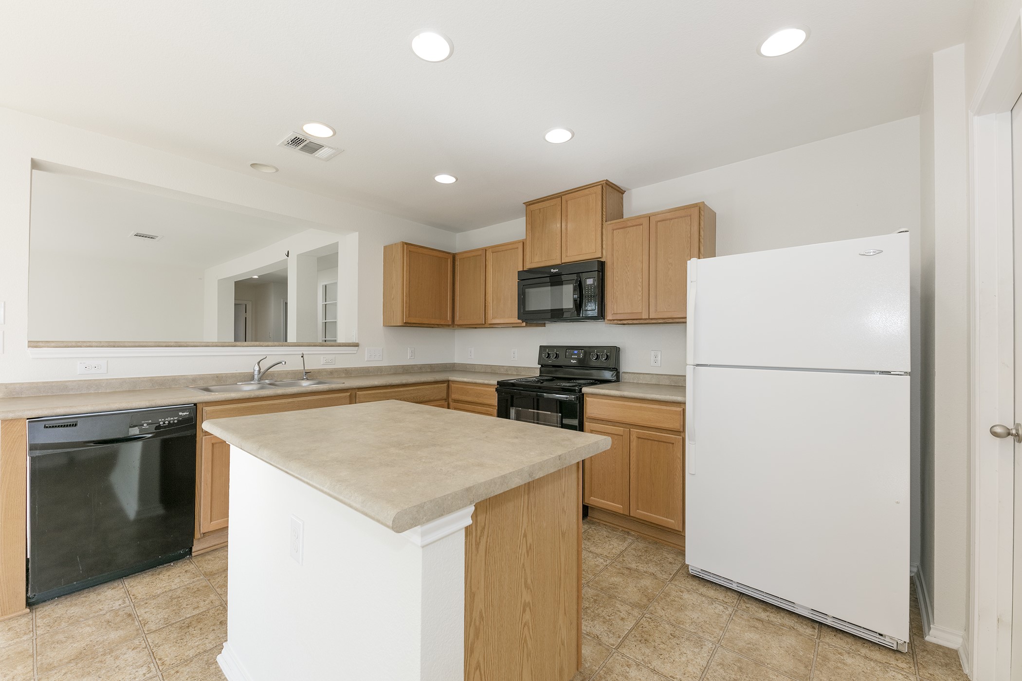 1141 Renaissance Trail Round Rock, TX 78665 - Photo 2 of 23 A well-equipped kitchen featuring an island, wooden cabinetry, and essential appliances.