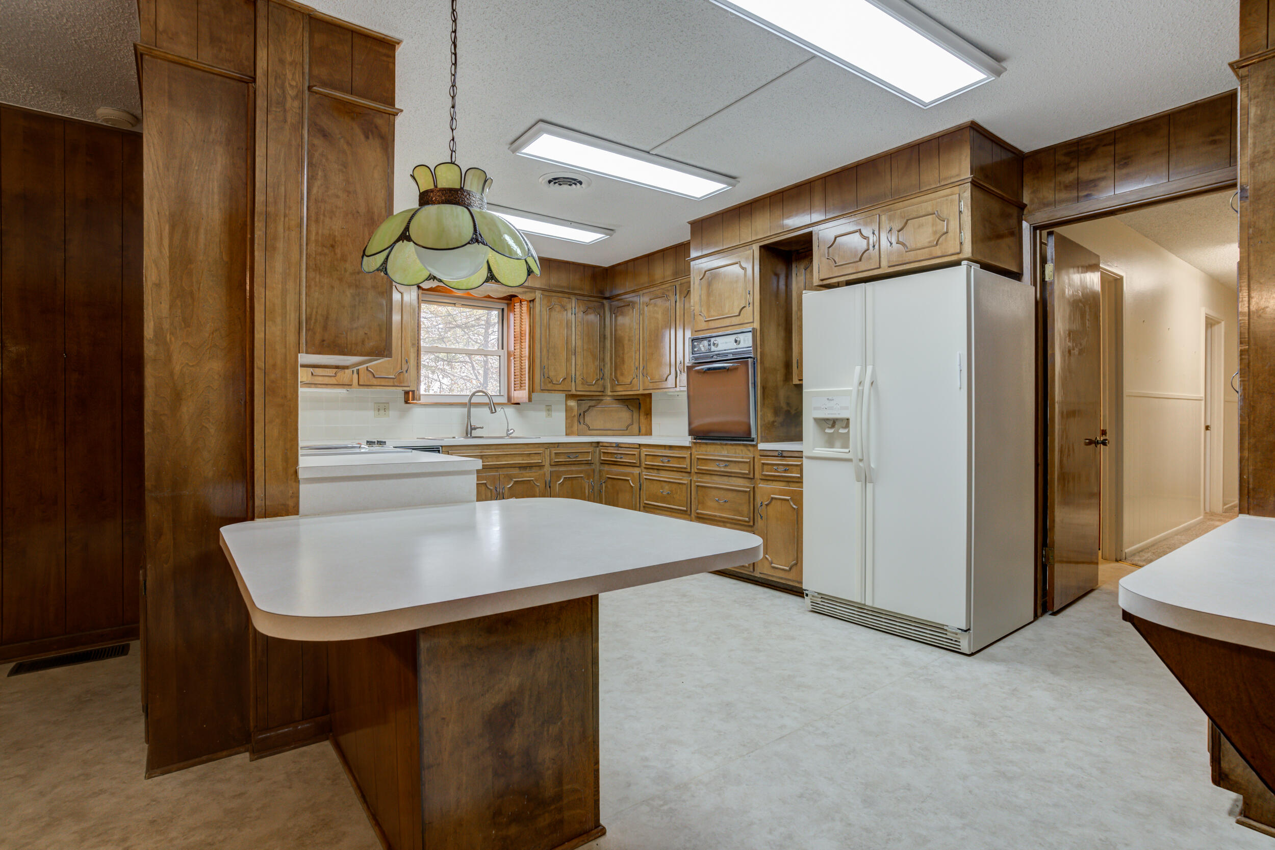 509 18th Street Seagraves, TX 79359 - Photo 13 of 25 a kitchen with kitchen island a sink refrigerator and cabinets