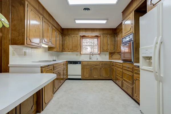 a kitchen with stainless steel appliances sink cabinets and window