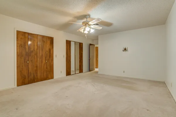 a view of an empty room with a ceiling fan