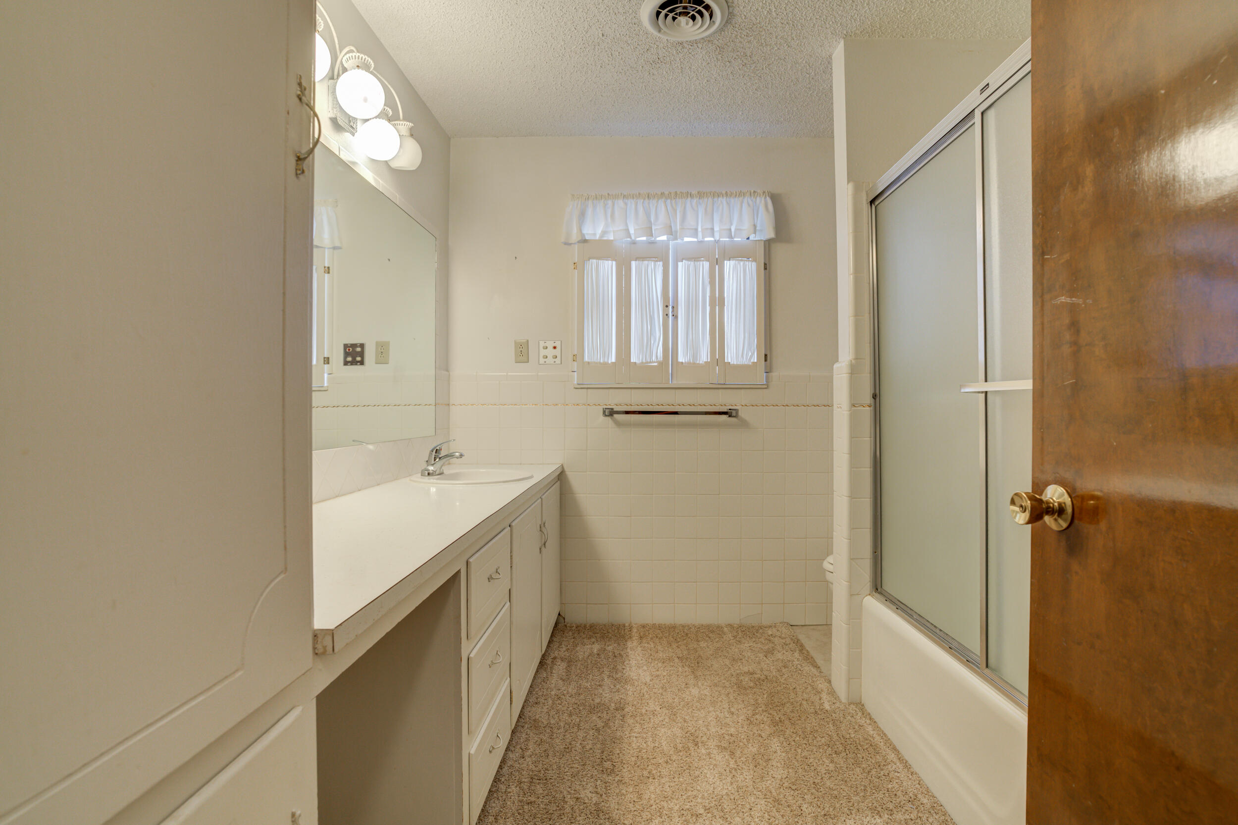 509 18th Street Seagraves, TX 79359 - Photo 23 of 25 a bathroom with a sink and a mirror