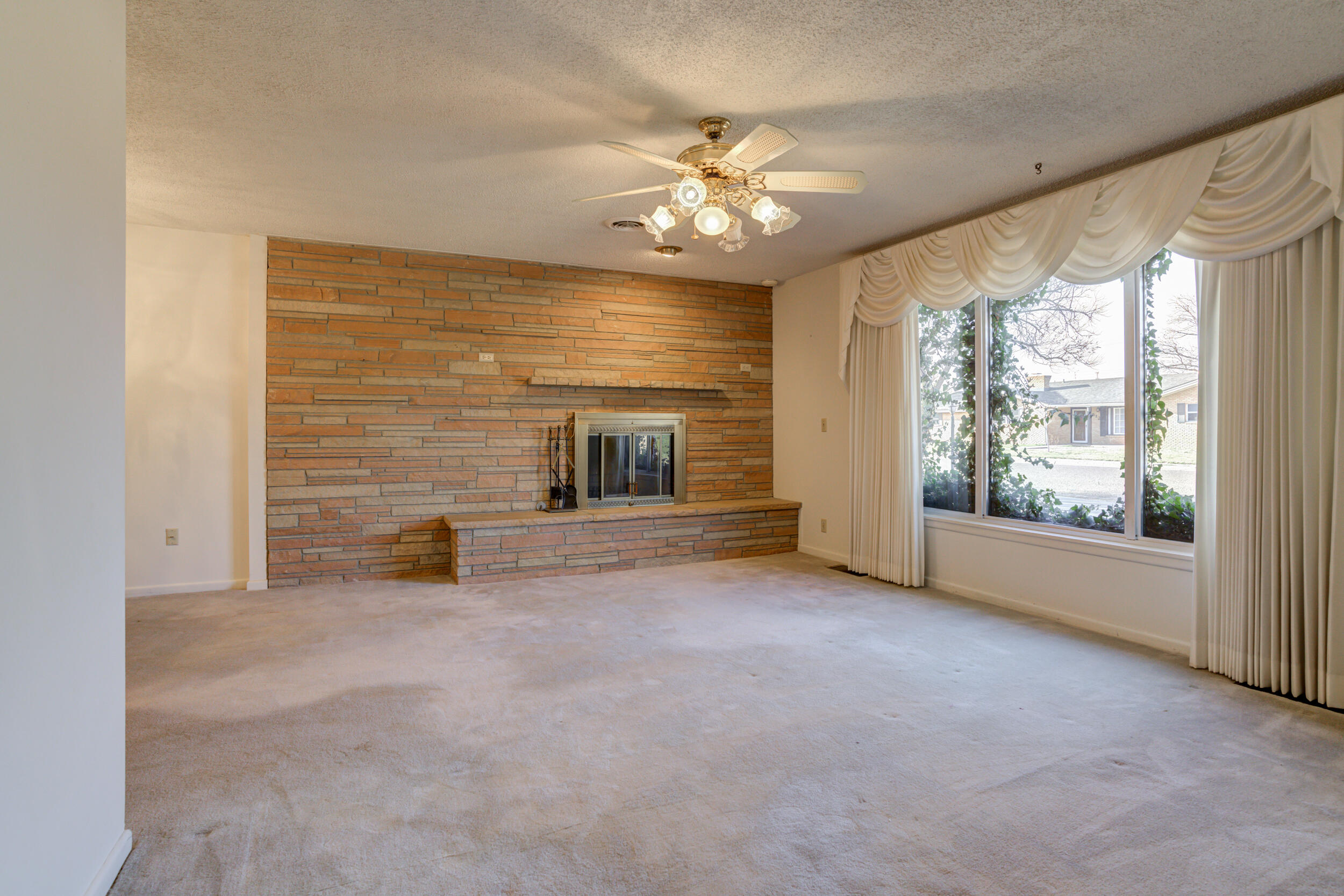 509 18th Street Seagraves, TX 79359 - Photo 6 of 25 en empty room with windows and fireplace