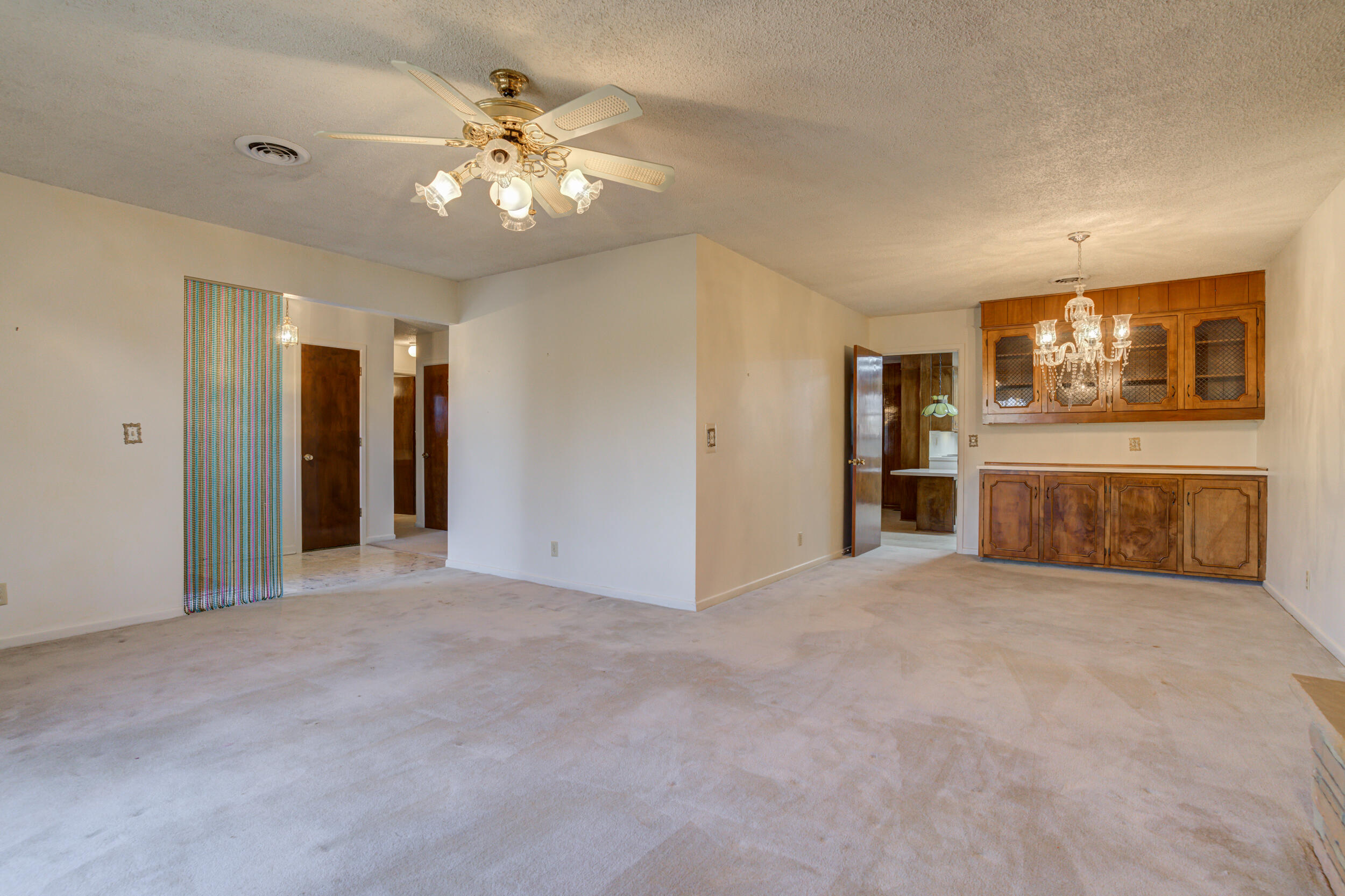 509 18th Street Seagraves, TX 79359 - Photo 7 of 25 a view of a livingroom with a fireplace a chandelier and a flat screen tv