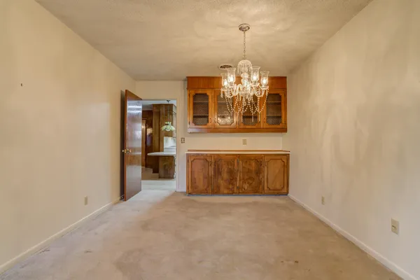 a view of a big room with windows and chandelier