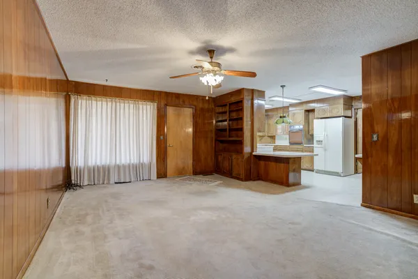 an empty room with closet and a ceiling fan