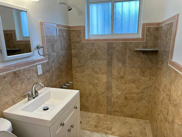 a bathroom with a sink mirror and shower