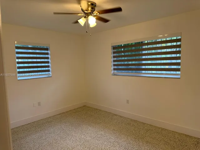 an empty room with a view of ceiling fan