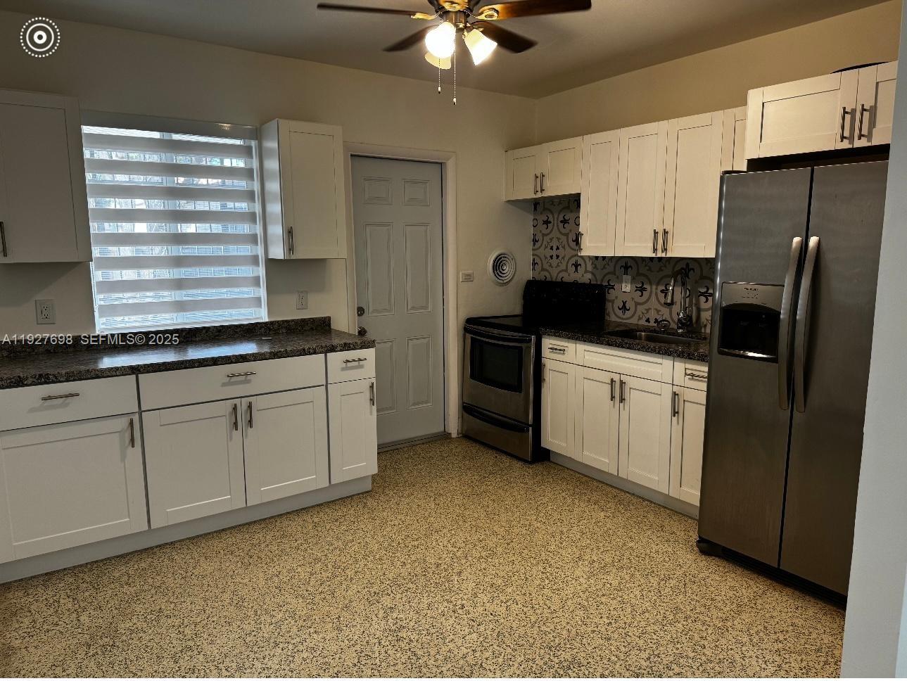 7071 Southwest 4th Street, Unit 2 Miami, FL 33144 - Photo 25 of 27 a kitchen with granite countertop a sink stainless steel appliances and white cabinets