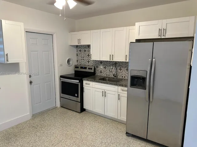 a kitchen with stainless steel appliances a refrigerator sink and cabinets