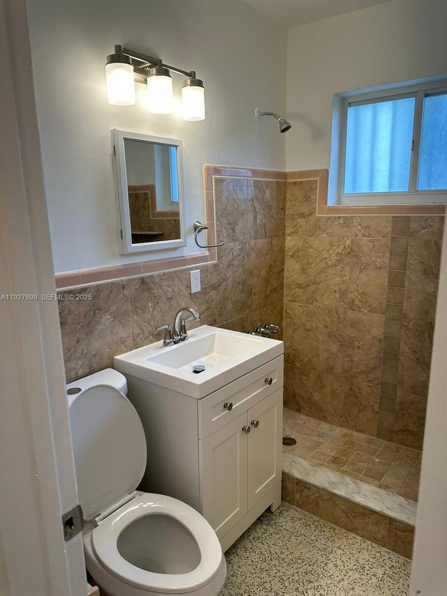 7071 Southwest 4th Street, Unit 2 Miami, FL 33144 - Photo 10 of 27 a bathroom with a toilet sink and mirror