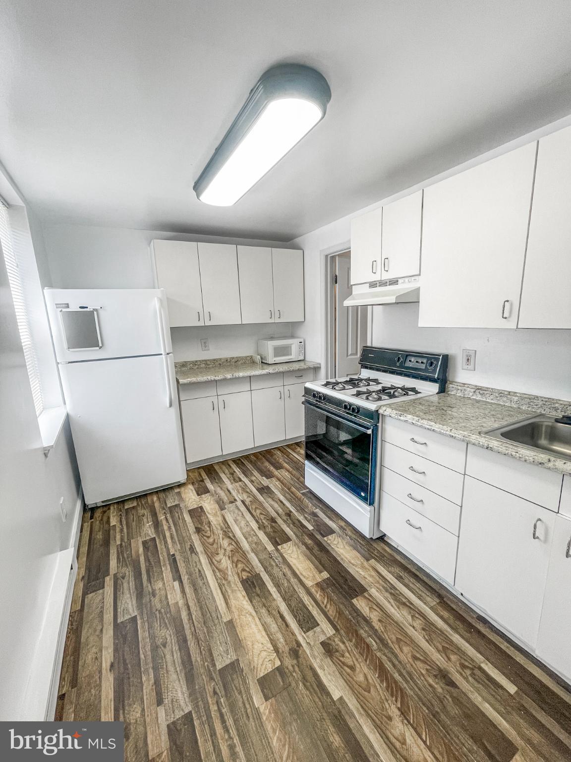1436 Light Street Baltimore, MD 21230 - Photo 10 of 21 a kitchen with a sink a stove top oven and white cabinets