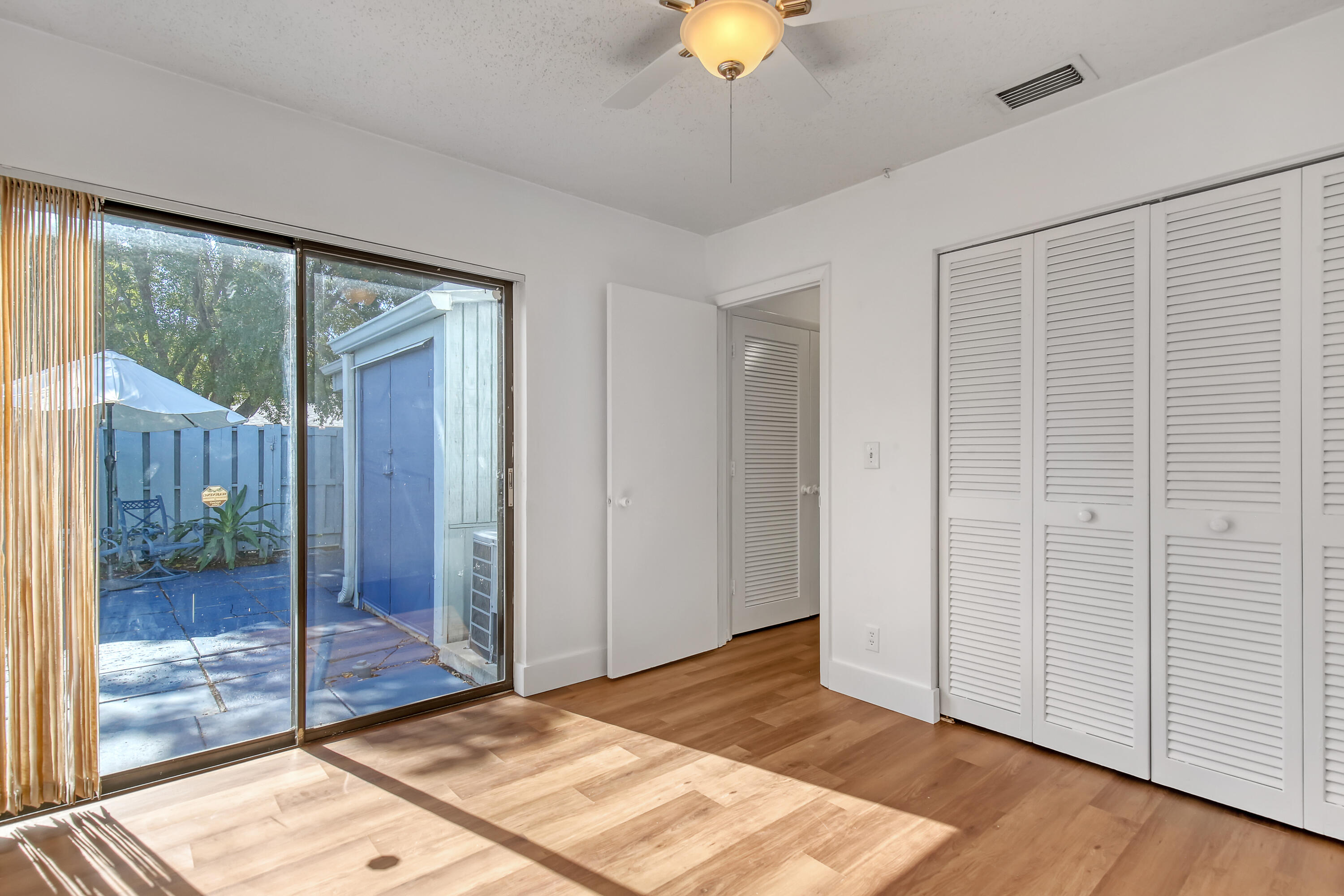 241 Northwest 15th Street Boca Raton, FL 33432 - Photo 28 of 34 a room that has a bed and a chandelier fan