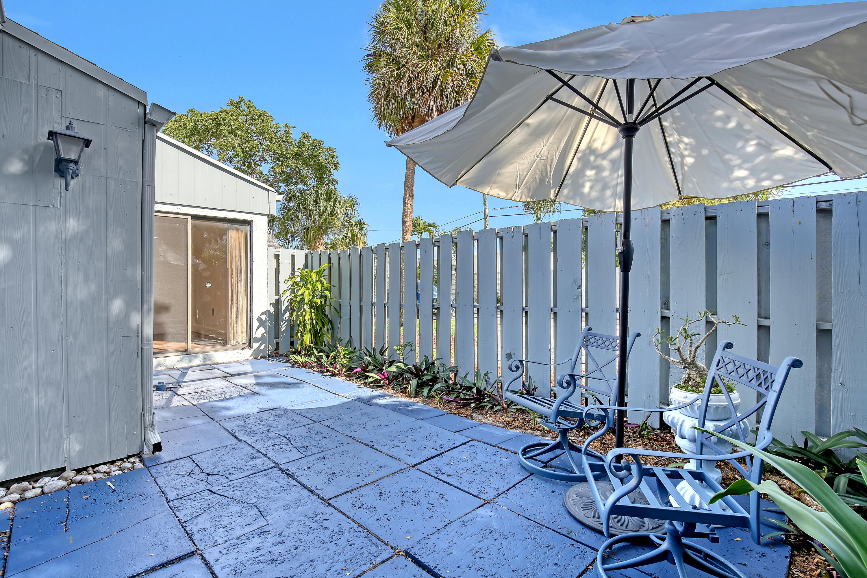 241 Northwest 15th Street Boca Raton, FL 33432 - Photo 31 of 34 a view of a backyard with table and chairs and a umbrella