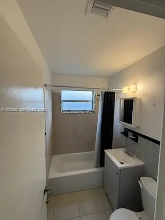 a bathroom with a tub sink and toilet