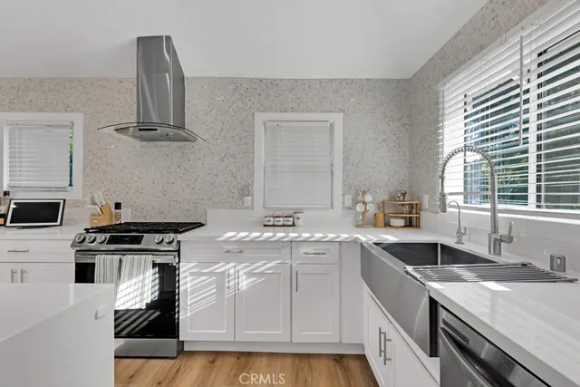 a kitchen with refrigerator a sink and chairs