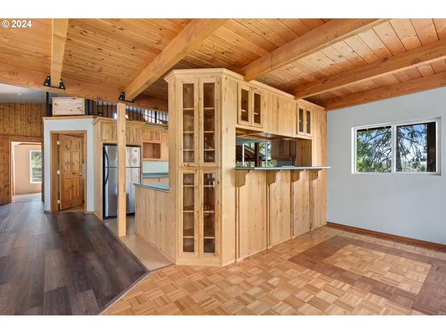 a view of a big room with wooden floor and windows