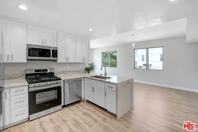 a kitchen with granite countertop a stove top oven and sink