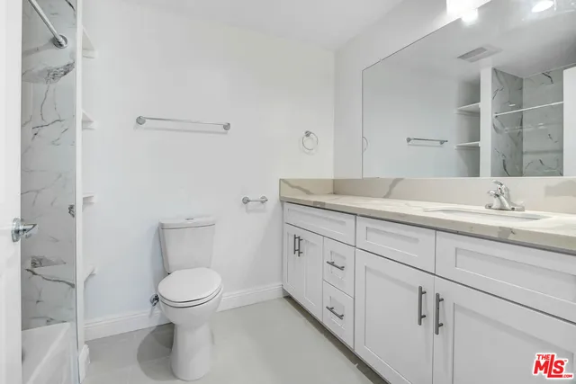 a spacious bathroom with a toilet sink and mirror