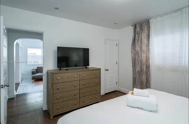 a bedroom with a bed and a flat screen tv