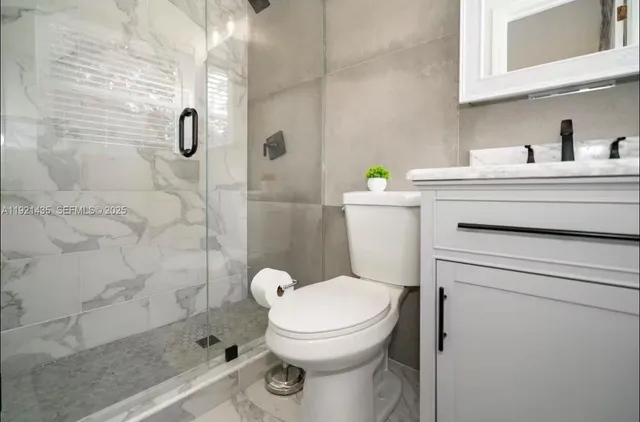 a bathroom with a toilet a sink and shower