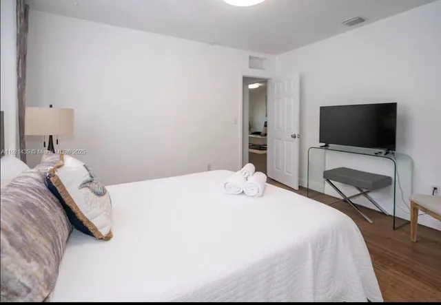 a bedroom with a bed and a flat screen tv