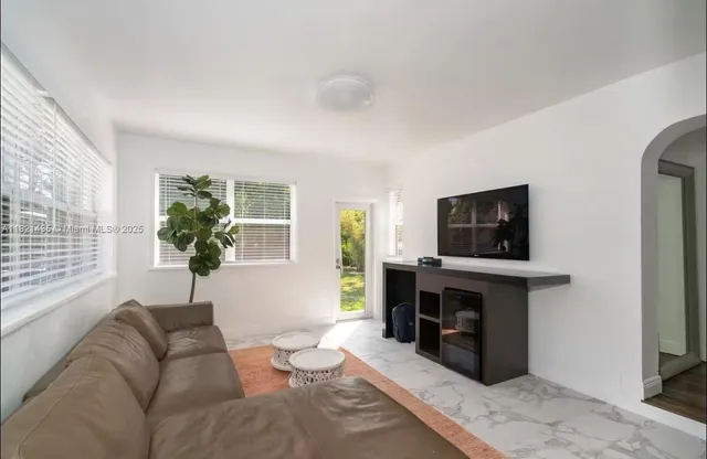 a living room with furniture a flat screen tv and a fireplace