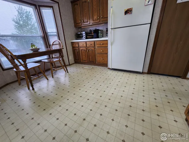 a kitchen with a refrigerator a stove a microwave and a dining table