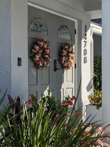 a front view of a house with a yard and potted plants