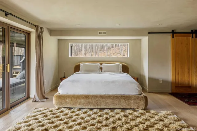 a bedroom with a bed and wooden floor