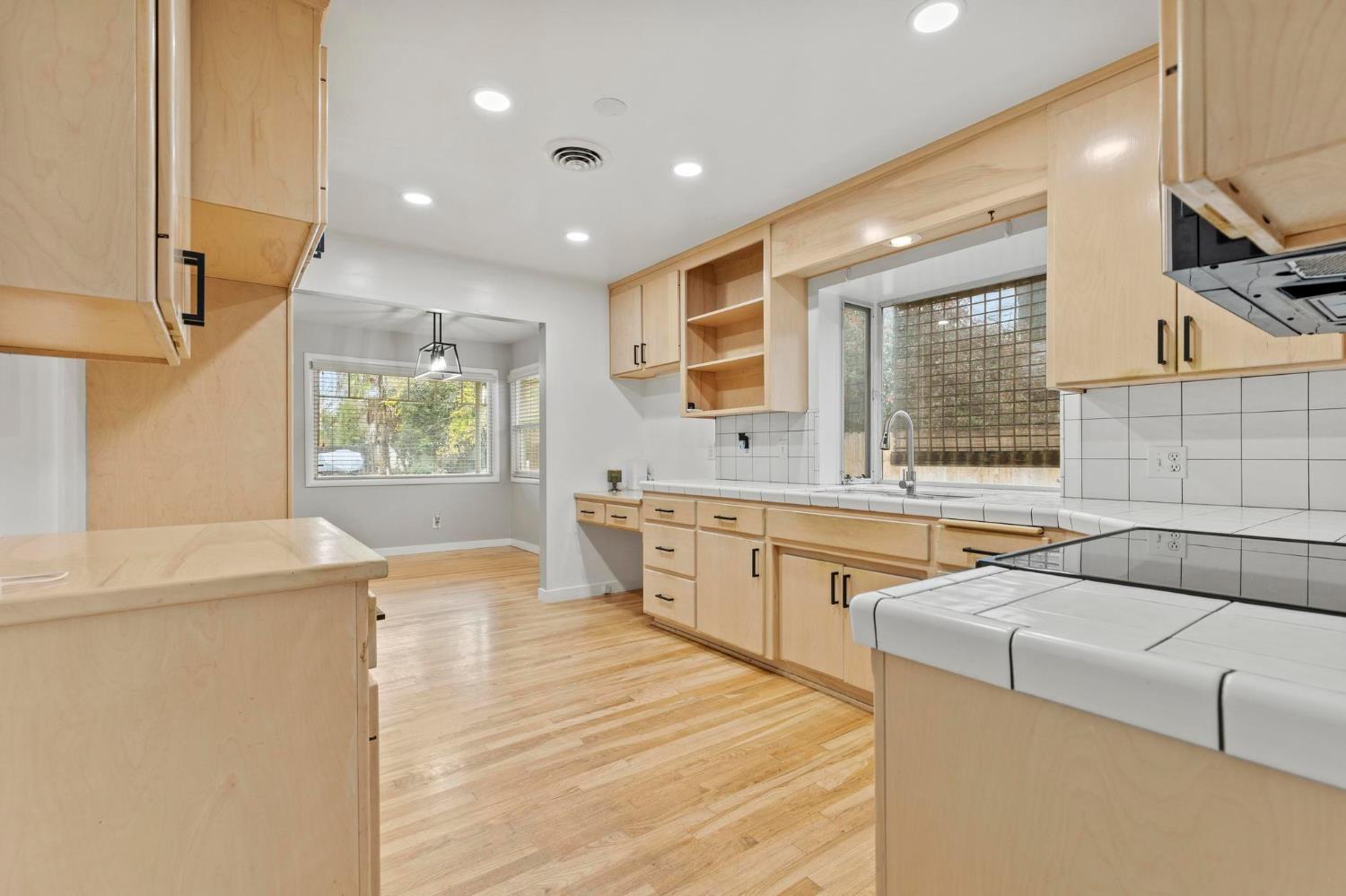 731 Sioc Street Colusa, CA 95932 - Photo 9 of 30 a view of a kitchen with kitchen island a sink wooden floor and a large window
