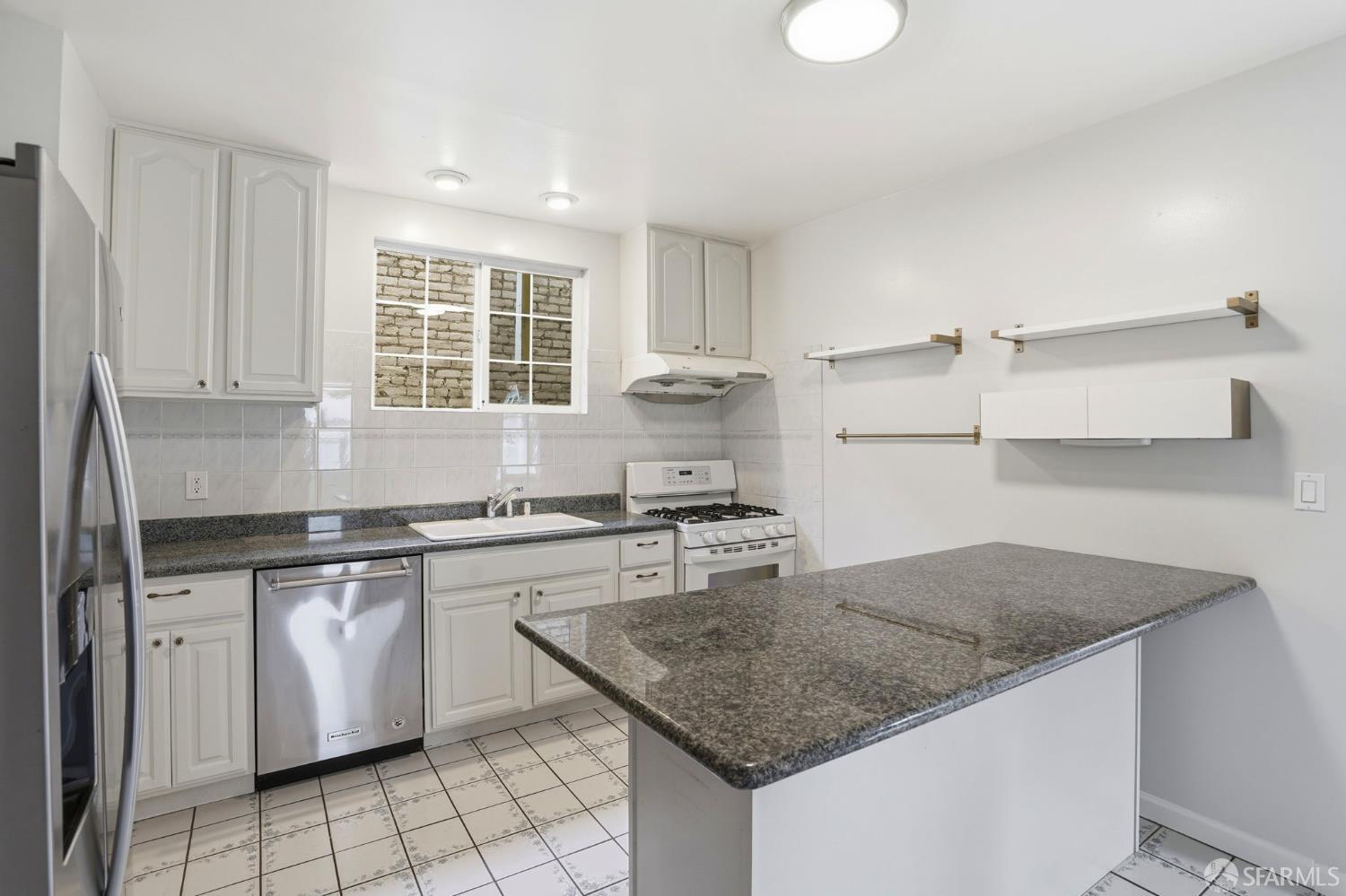 2811-2815 Telegraph Avenue Berkeley, CA 94705 - Photo 23 of 73 a kitchen with granite countertop a sink stove and cabinets