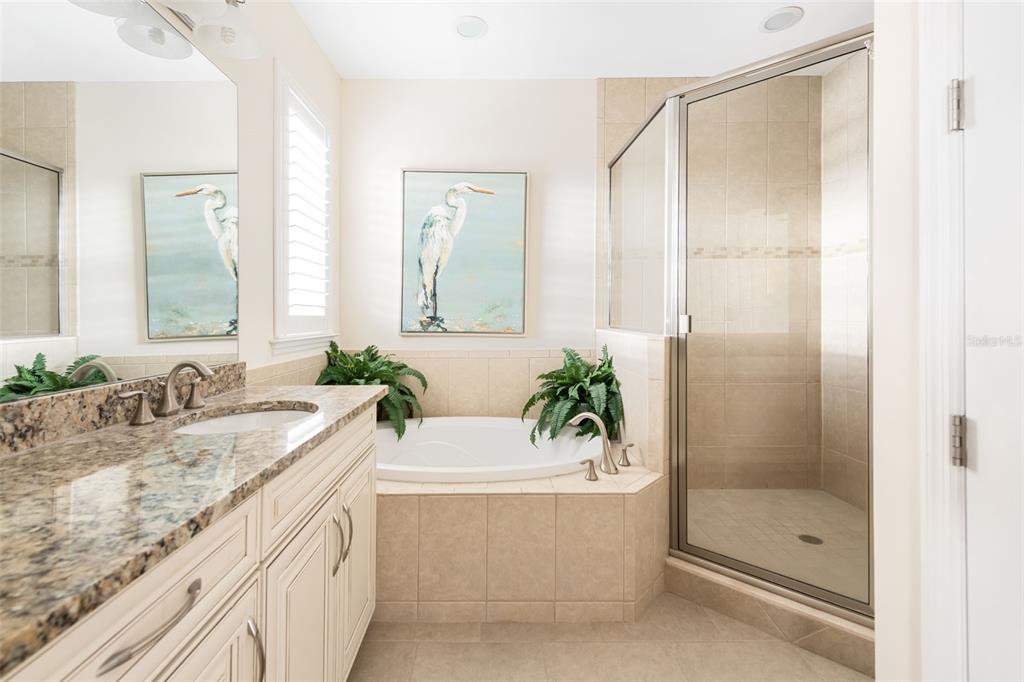10311 Lands End Circle, Unit 16 Placida, FL 33946 - Photo 27 of 76 a bathroom with a granite countertop bathtub shower sink and mirror