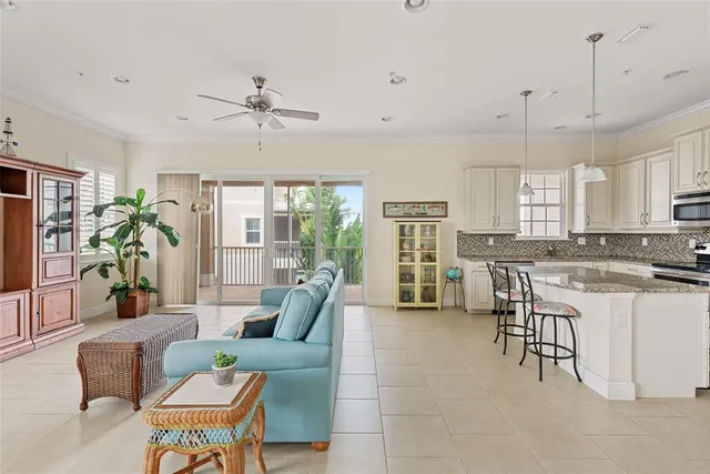 a living room with furniture floor to ceiling window and a potted plant