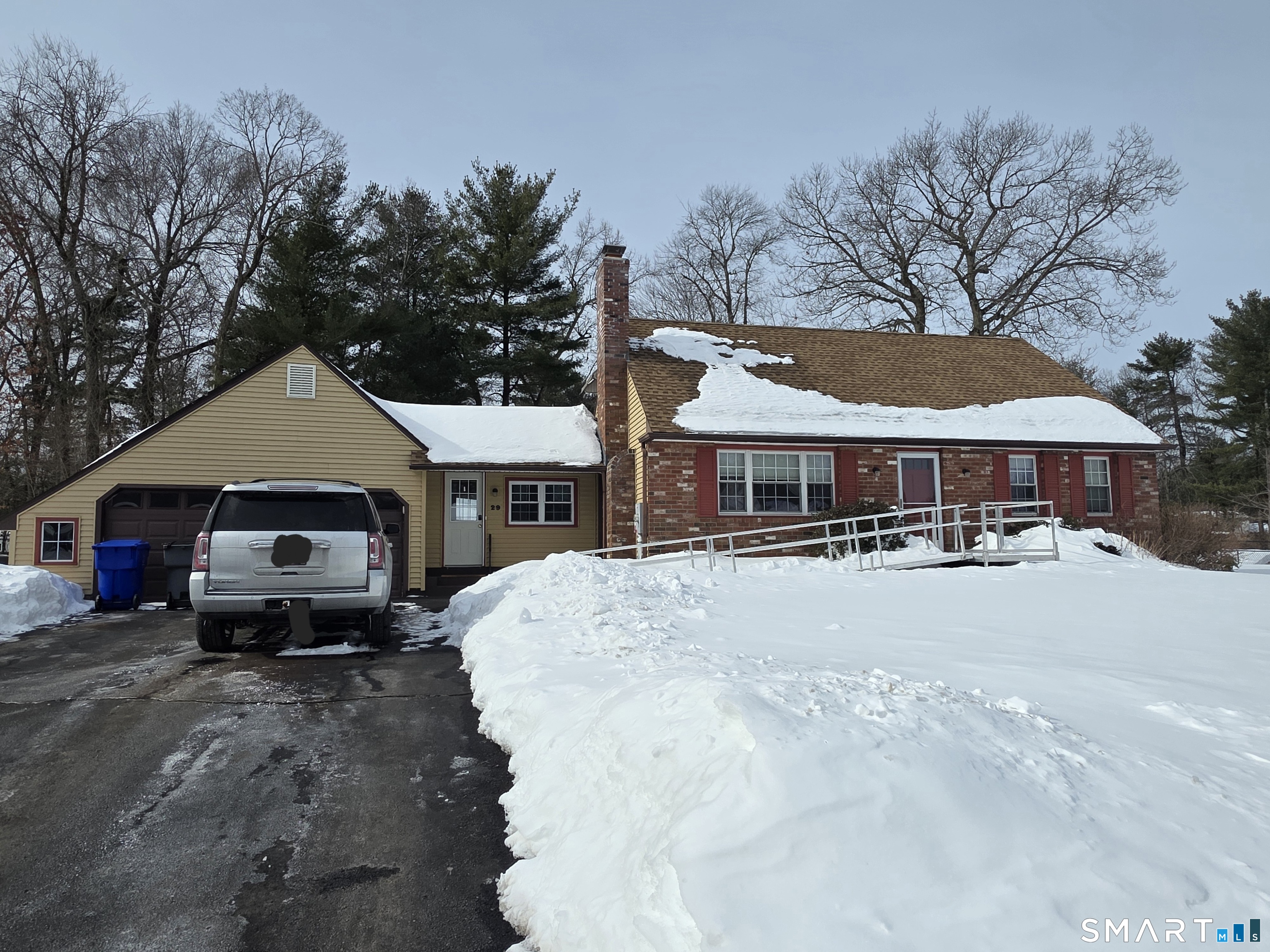 a front view of a house with yard covered in snow
