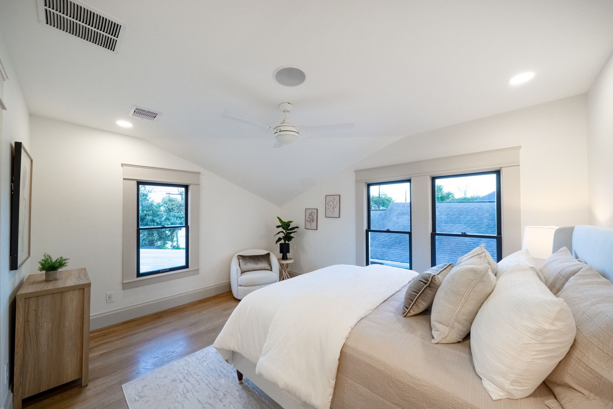 1109 Rutland Street Houston, TX 77008 - Photo 17 of 34 Bask in the tranquility of this light-filled primary bedroom, where natural sunlight streams through expansive windows, casting a warm glow across the serene, airy space. This retreat invites you to unwind and recharge, surrounded by calming tones and an atmosphere of pure relaxation.