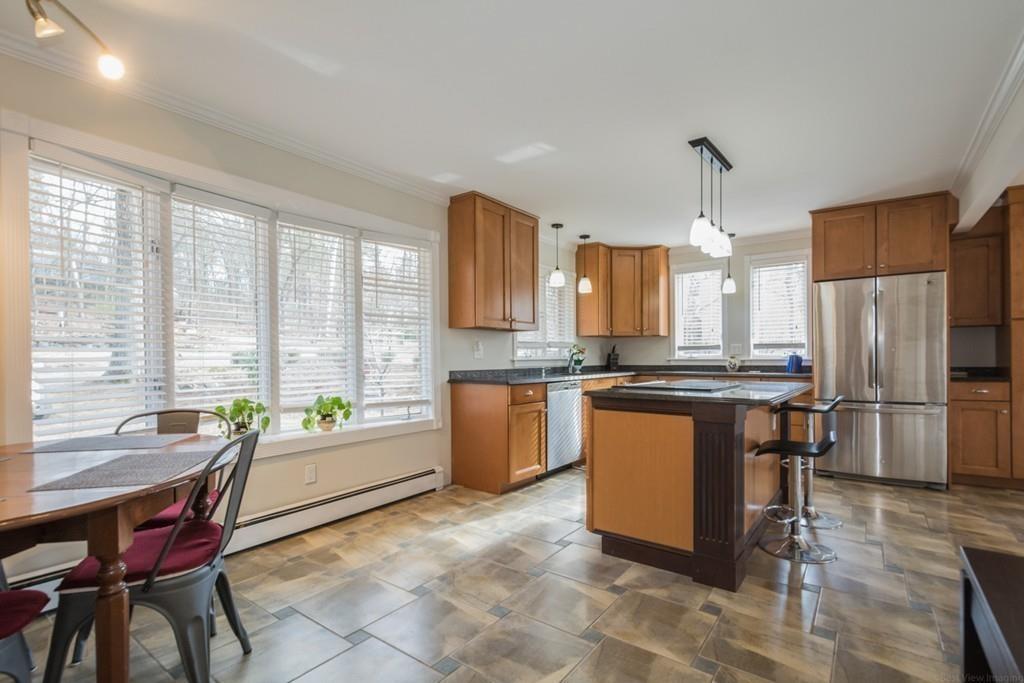 35 Barton Road Stow, MA 01775 - Photo 3 of 28 a kitchen with stainless steel appliances kitchen island granite countertop a refrigerator a stove a sink a dining table and chairs with wooden floor