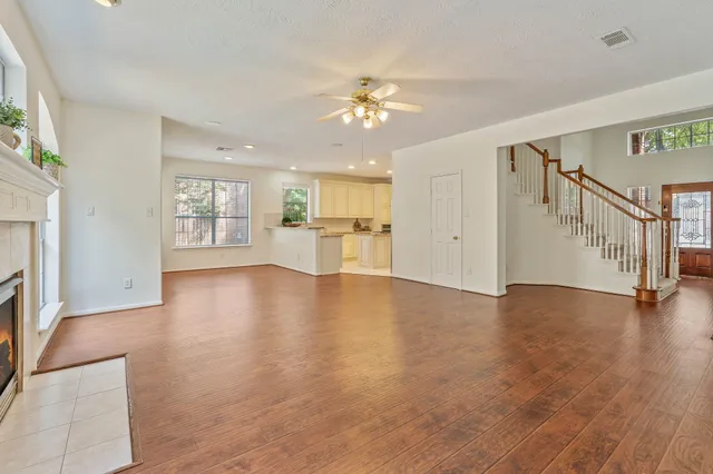 a view of an empty room with a window and wooden floor