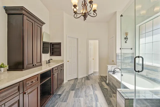 a spacious bathroom with a granite countertop sink a mirror and shower