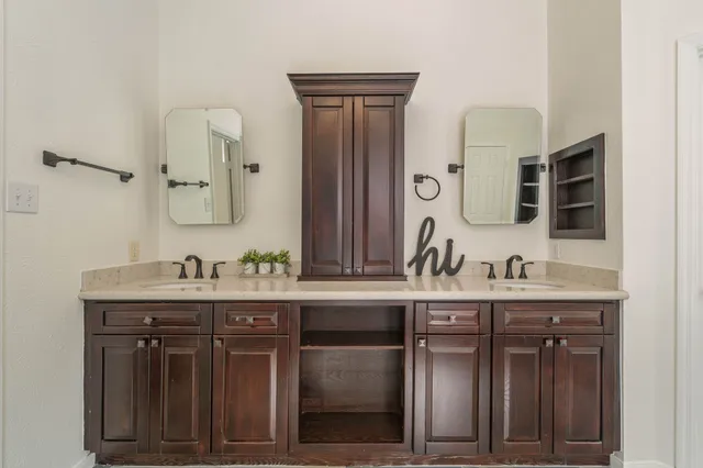 a bathroom with a granite countertop sink a mirror and cabinets