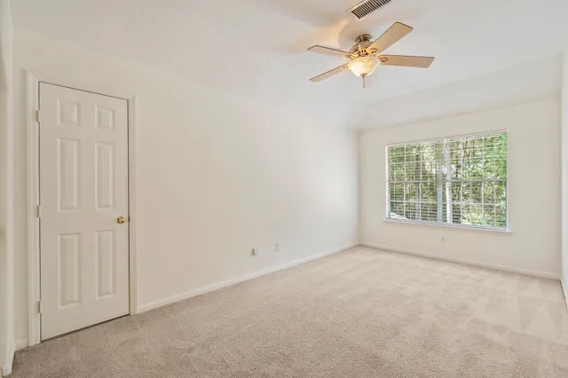 an empty room with a window and a fan